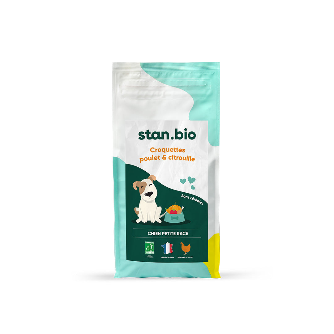 Un sac de croquettes sans céréales bio pour chien de petite race est au centre de l’image. Le sac contient des croquettes naturelles saveur poulet et citrouille. Le fond est blanc.