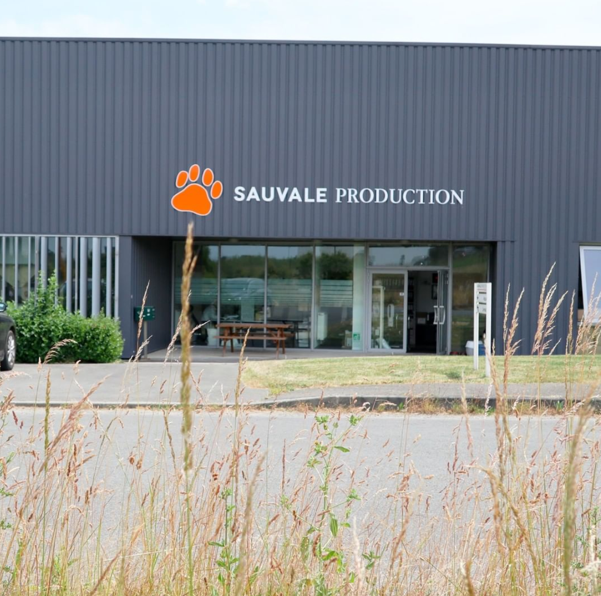 Usine Stan Bio de production croquettes chats et chiens Sauvale Production à Château-Gontier en Mayenne façade grise avec logo patte orange