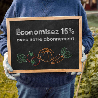 Un agriculteur tient une ardoise dans ses mains indiquant que l’abonnement de la marque stan.bio pour des produits bio, permet d’économiser de 15% à vie.