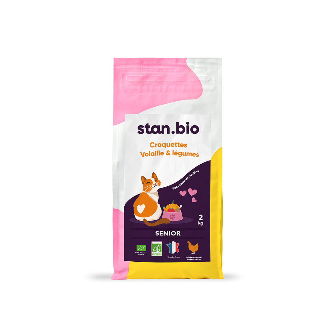 Un sachet de croquettes sans céréales allégées bio pour chat est au centre de l'image. C'est un sac de 2 kg coloré en jaune, rose, violet et blanc.