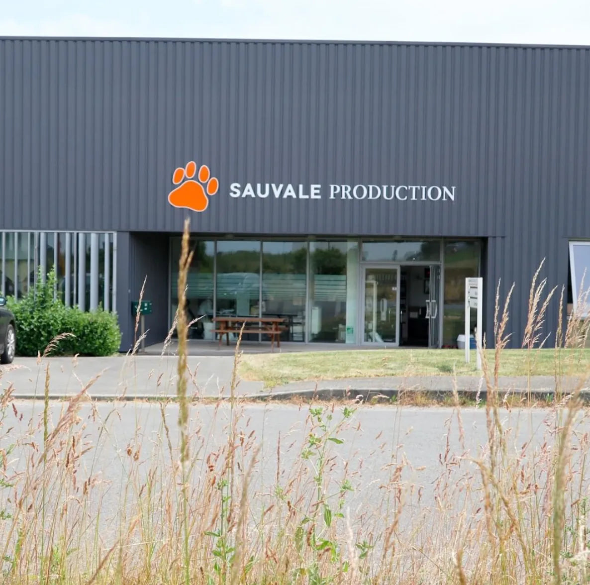 Usine Stan Bio de production croquettes chats et chiens Sauvale Production à Château-Gontier en Mayenne façade grise avec logo patte orange