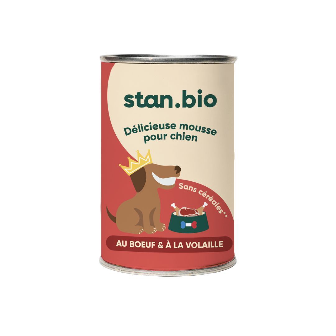 Une boîte de terrine sans céréales bio pour chien est au centre de l'image. La boîte est rouge, beige et vert. Le fond est blanc.